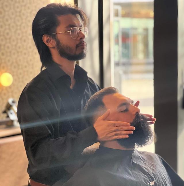 bilde av barberer som sjekker skjegget til kunde
