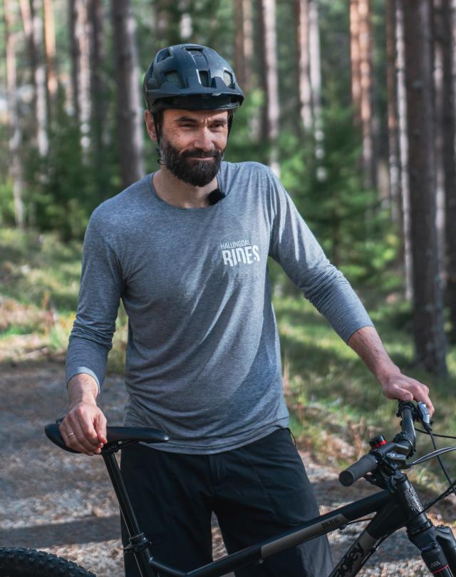 Prosjektleder Lars Wraae Jensen står ute i en terrengsykkelbane og smiler fornøyd.